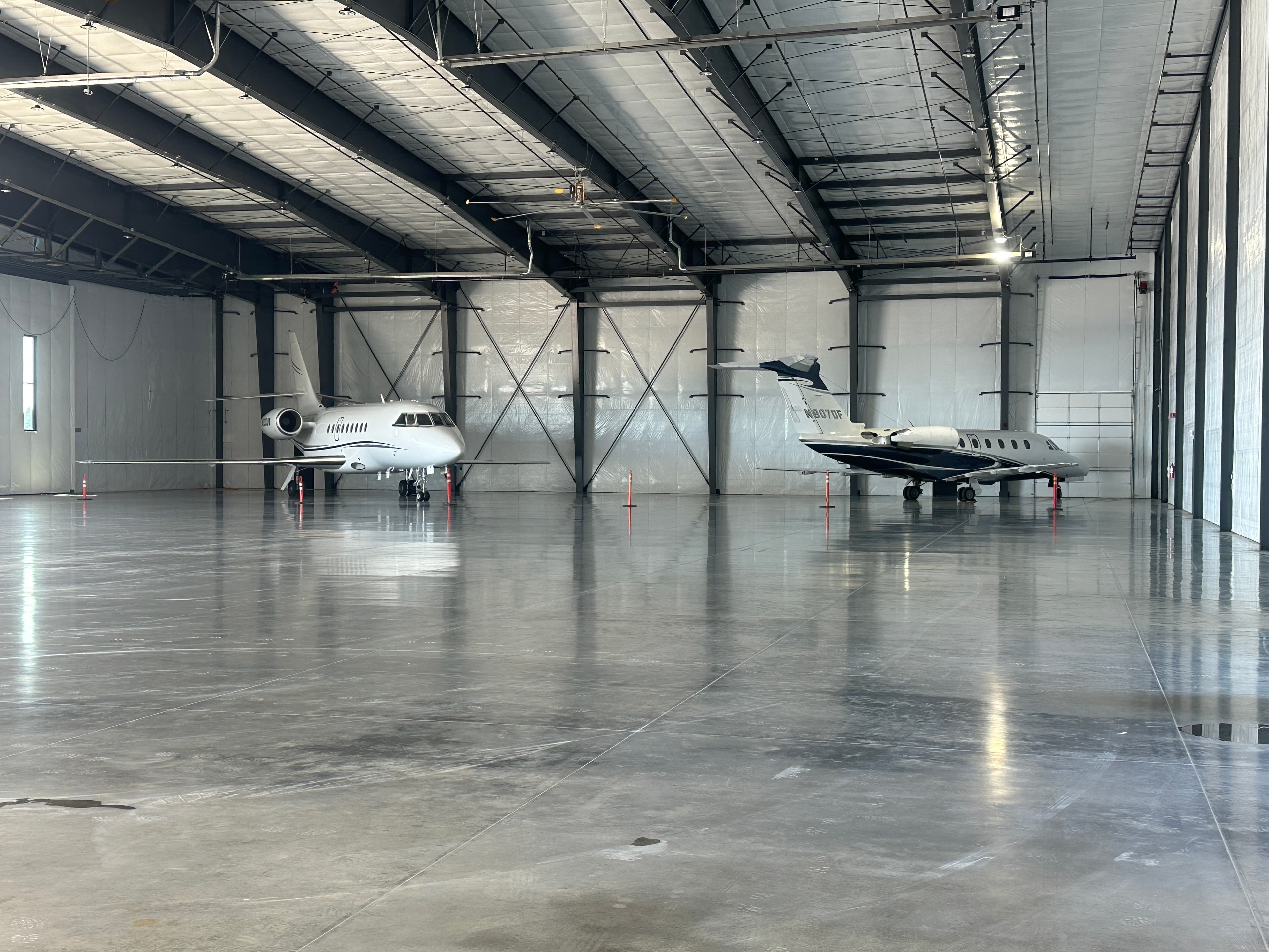 Two aircraft inside a commercial airport hangar